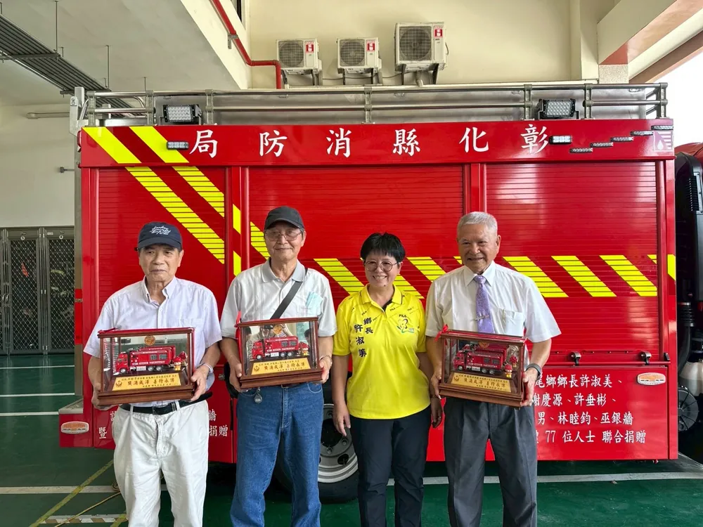 消防車前,鄉長與三位捐贈者各手捧消防車模型紀念牌