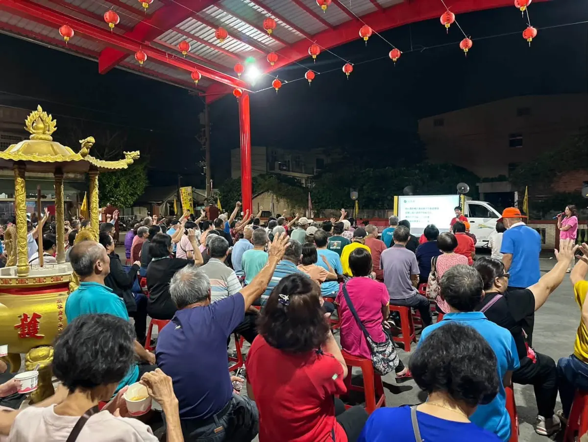 沛霖宮廣場坐滿鄉親，大家舉手回應，前方螢幕播放簡報