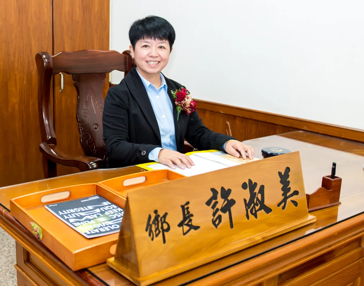 許淑美鄉長坐在鄉長辦公室的辦公桌前，桌上擺著鄉長名牌